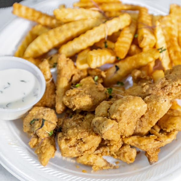 Plant Bae's vegan fried chicken and crinkle-cut fries with a side of dipping sauce.