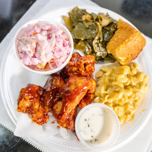 Plant Bae's vegan meal with BBQ wings, mac and cheese, collard greens, cornbread, coleslaw, and ranch.